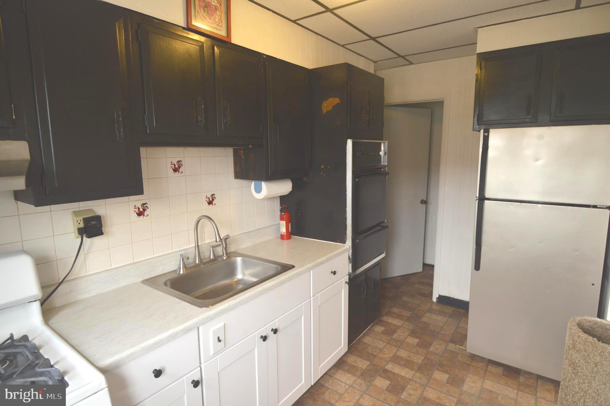 9742 Conmar Road Baltimore, MD 21220 - Photo 7 of 22 a kitchen with a sink and refrigerator