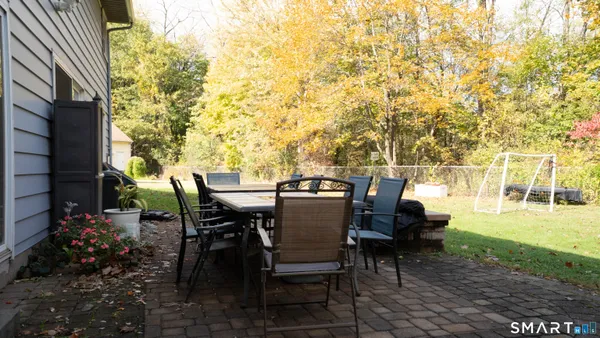 a view of a patio with table and chairs with plants and wooden fence
