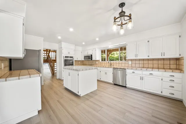 a kitchen with granite countertop cabinets stainless steel appliances and a wooden floor