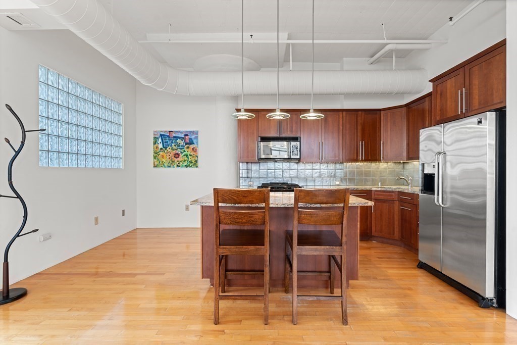 437 D Street, Unit 6A Boston, MA 02210 - Photo 12 of 26 a kitchen with a table chairs refrigerator and microwave