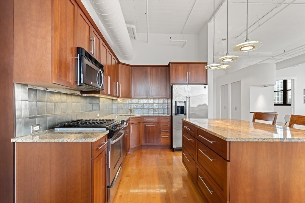 437 D Street, Unit 6A Boston, MA 02210 - Photo 13 of 26 a kitchen with granite countertop a sink stove and cabinets
