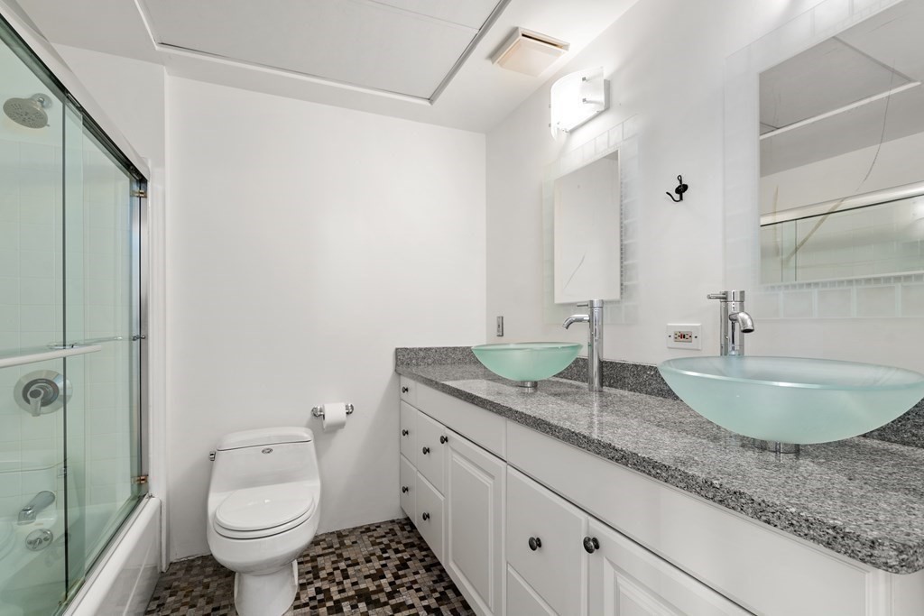 437 D Street, Unit 6A Boston, MA 02210 - Photo 17 of 26 a bathroom with a granite countertop sink a mirror and a toilet