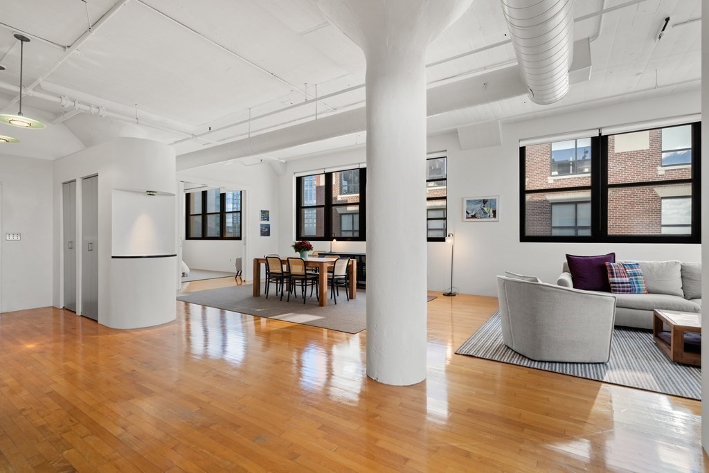 437 D Street, Unit 6A Boston, MA 02210 - Photo 5 of 26 a living room with couches and kitchen view with wooden floor