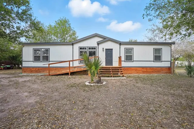 a view of a house with backyard and trees