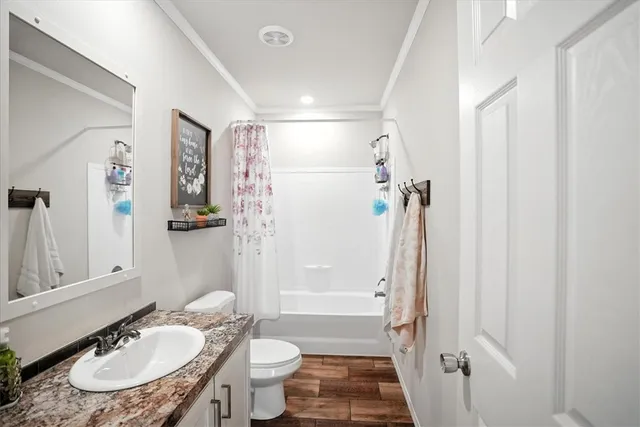 a bathroom with a sink toilet a mirror and shower