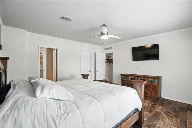 a bedroom with a bed and a flat tv screen on wall