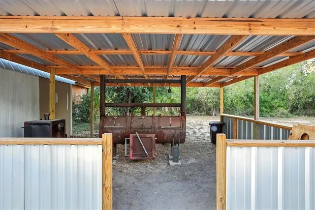 a view of a patio with table and chairs under an umbrella with a small yard