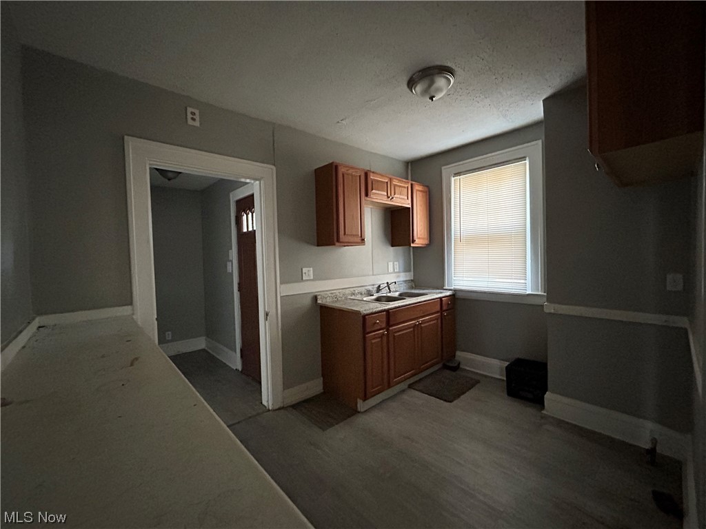 13604 Claiborne Road Cleveland, OH 44112 - Photo 6 of 18 Kitchen featuring a textured ceiling, light countertops, and dark hardwood flooring