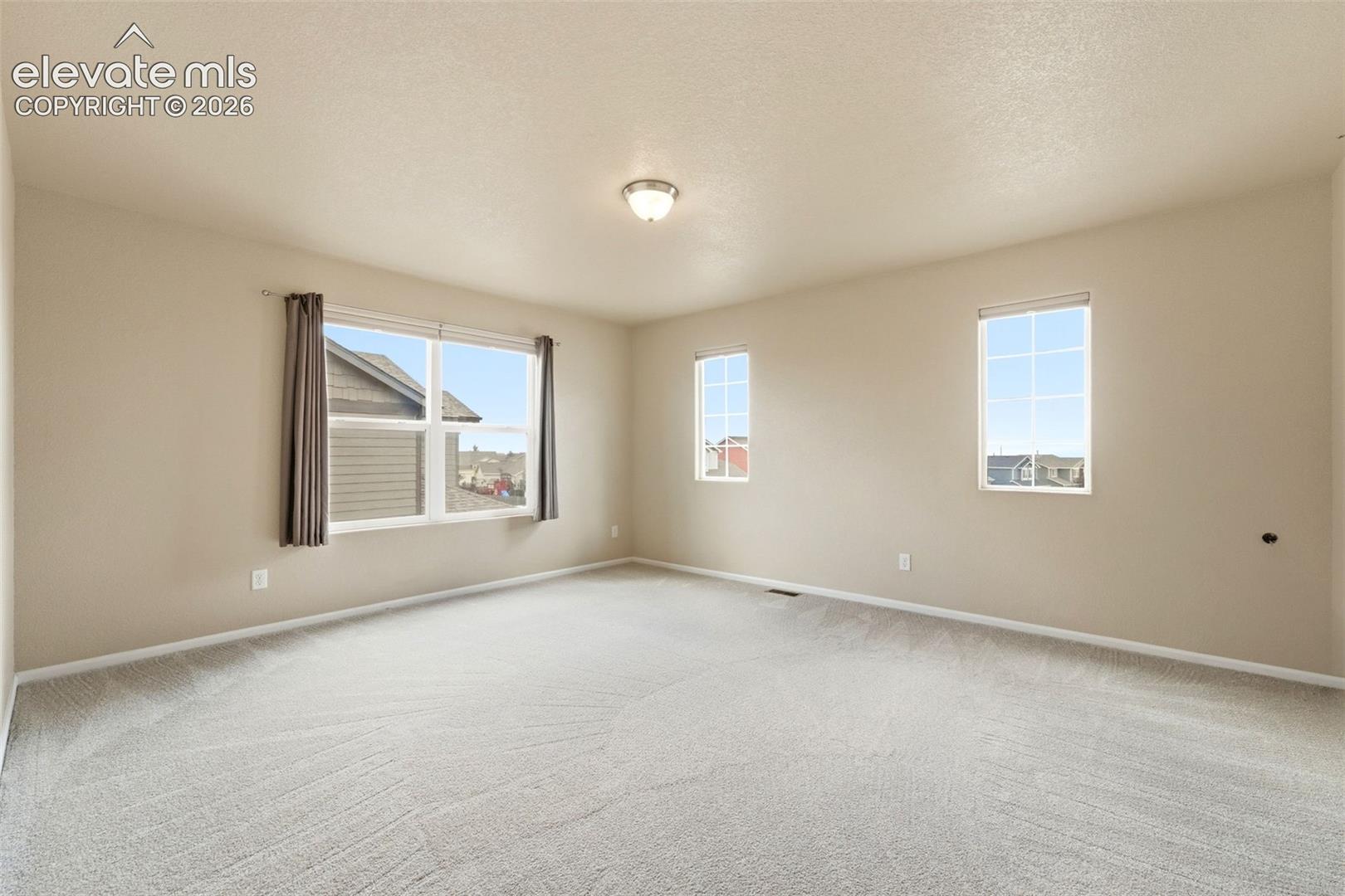 7274 Red Cardinal Loop Colorado Springs, CO 80908 - Photo 11 of 33 Light-toned wall paint, multiple windows, recessed lighting, and carpeted flooring