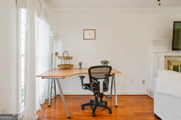 a view of a workspace with furniture and a window