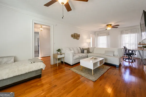 a living room with furniture and wooden floor