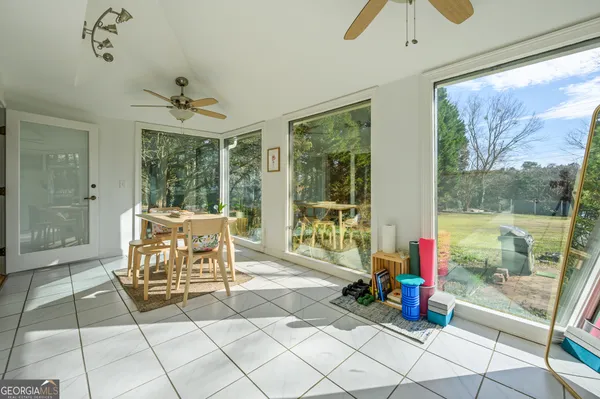 a living room with glass windows and furniture
