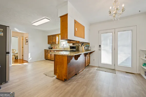 a kitchen with stainless steel appliances granite countertop a sink a counter space and wooden floor
