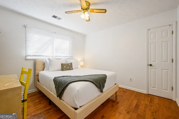 a bedroom with a bed and a chandelier fan