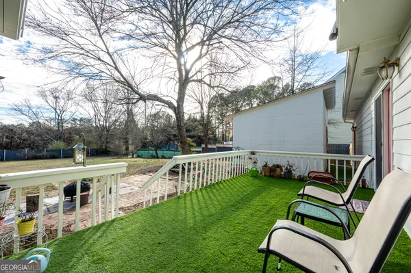 a view of backyard with seating area barbeque oven and trees
