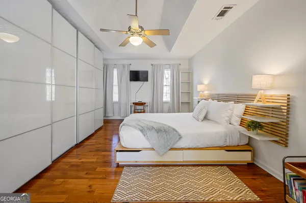 a spacious bedroom with a bed and a chandelier