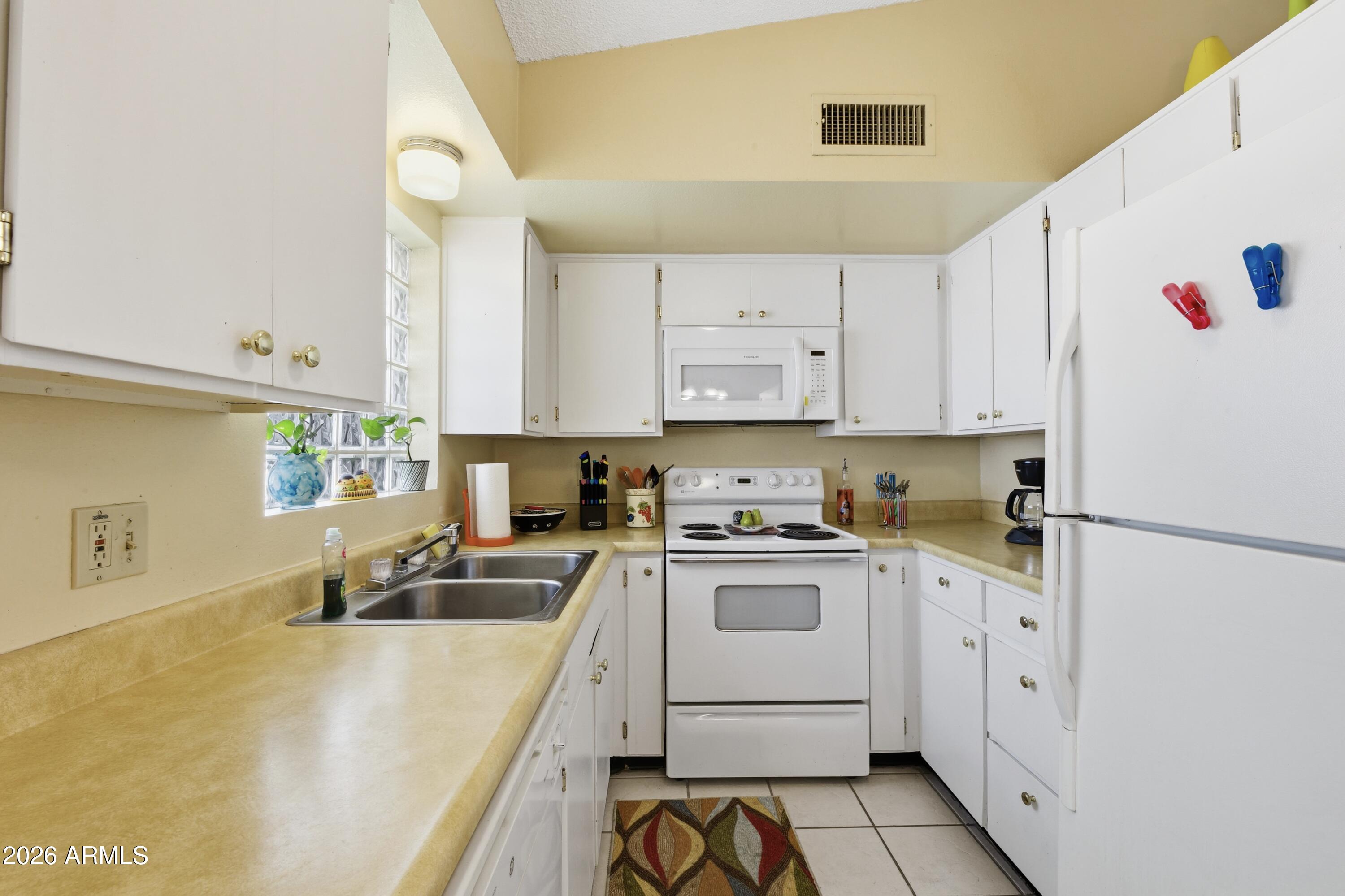 641 South Power Road, Unit 366 Mesa, AZ 85206 - Photo 3 of 22 a kitchen with a sink a stove and white cabinets