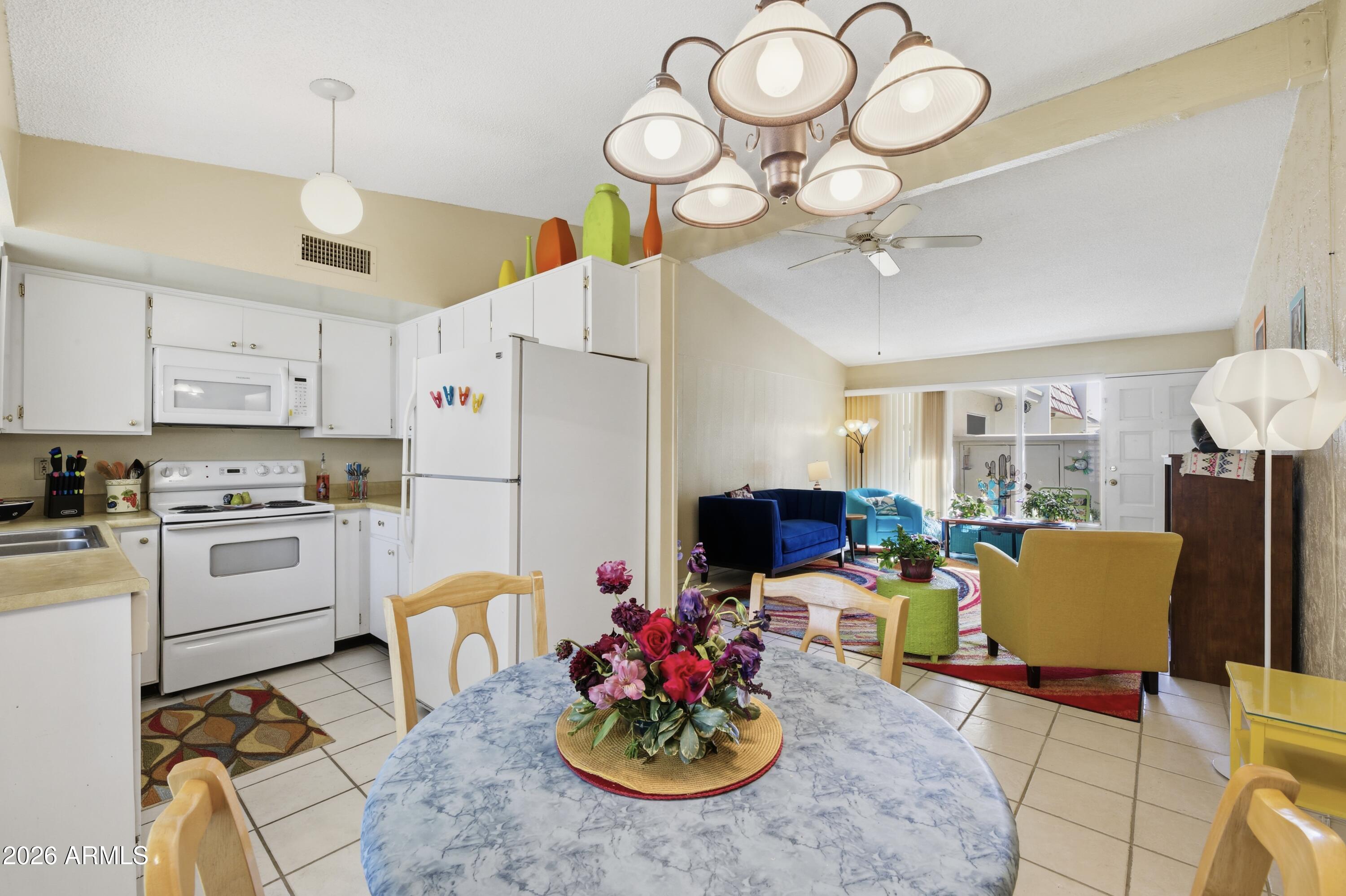 641 South Power Road, Unit 366 Mesa, AZ 85206 - Photo 4 of 22 a kitchen with stainless steel appliances kitchen island granite countertop a stove a sink dishwasher a dining table and chairs with wooden floor