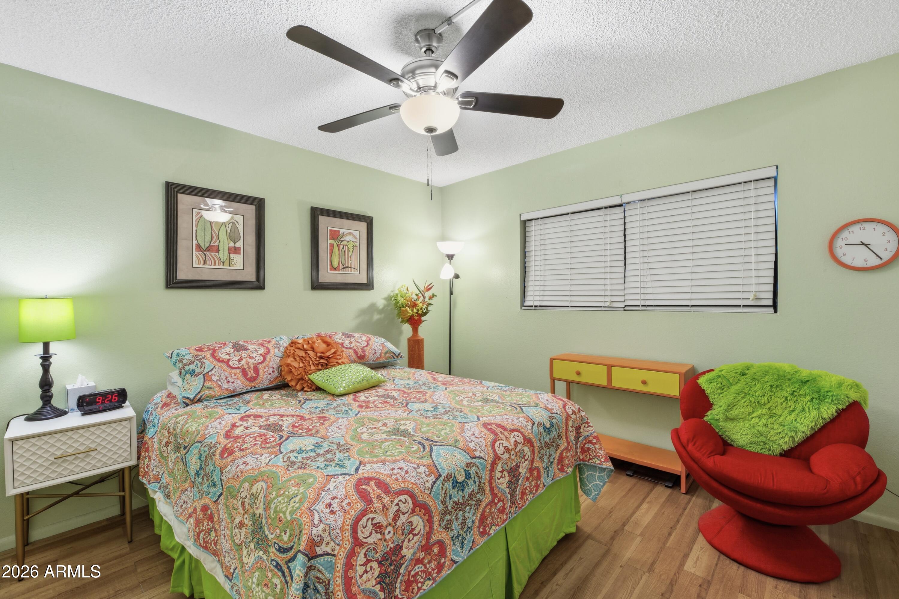 641 South Power Road, Unit 366 Mesa, AZ 85206 - Photo 10 of 22 a bedroom with a bed and a chair