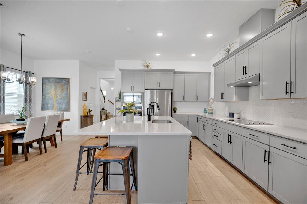 731 FIREROCK Lane DeBary, FL 32713 - Photo 4 of 39 a large white kitchen with lots of counter space and dining table
