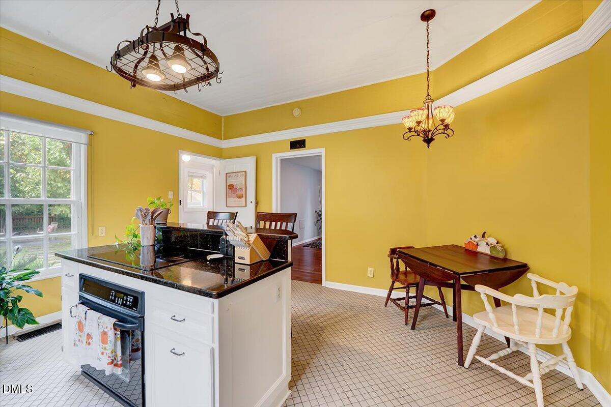 230 Brick Street Wake Forest, NC 27587 - Photo 14 of 38 a kitchen with a table chairs refrigerator and cabinets