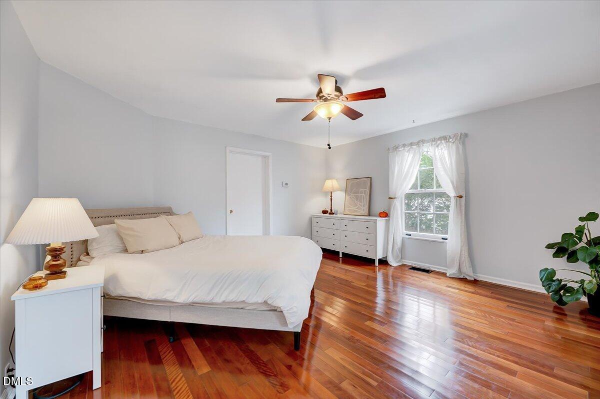230 Brick Street Wake Forest, NC 27587 - Photo 4 of 38 a bedroom with a bed chandelier and a window