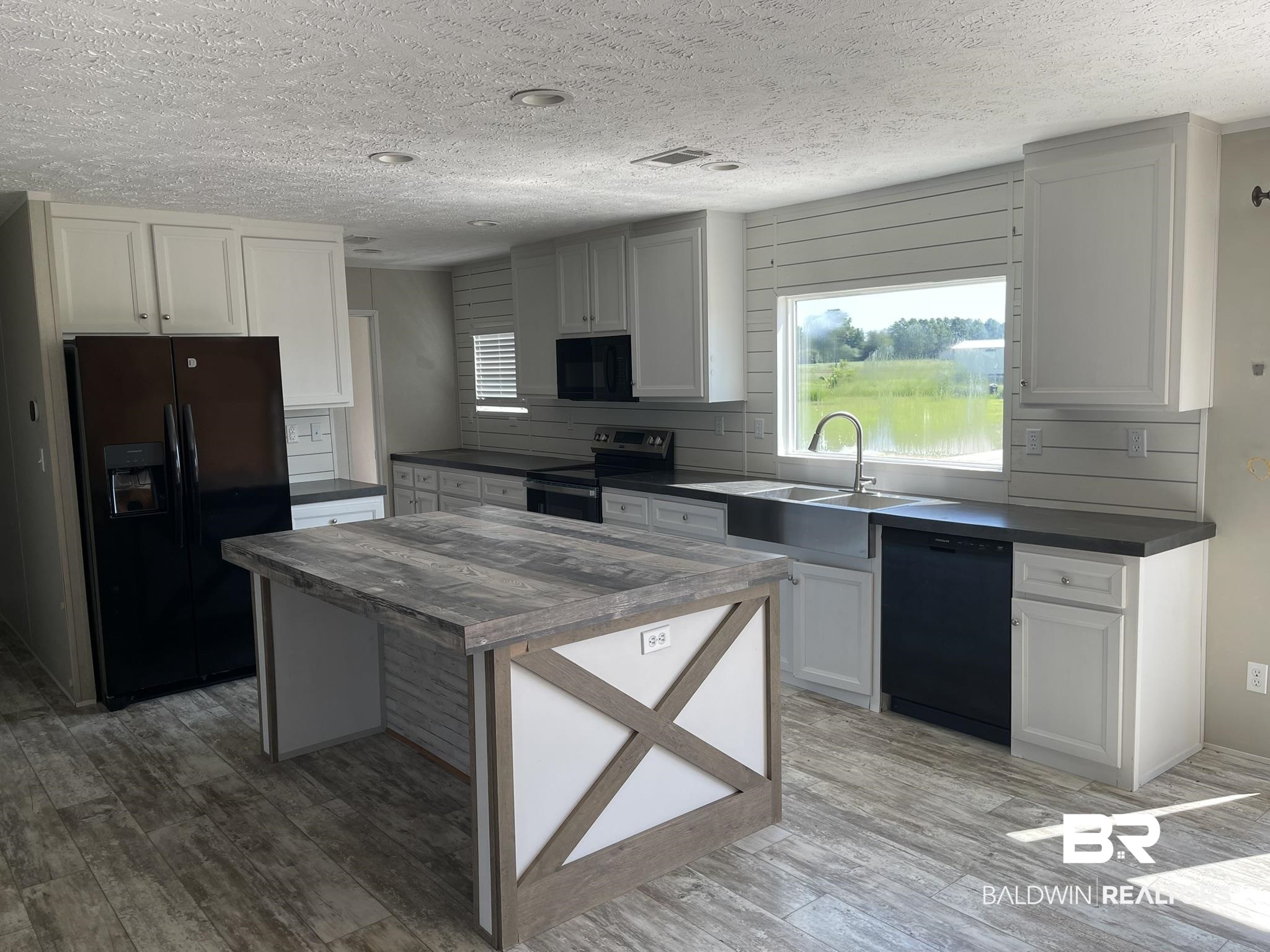 16802 County Road 87 Elberta, AL 36530 - Photo 3 of 19 Kitchen featuring dark countertops, black appliances, a textured ceiling, white cabinets, and light wood-type flooring