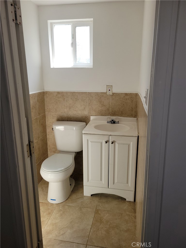 3534 139th Street Hawthorne, CA 90250 - Photo 7 of 7 a bathroom with a toilet a sink a window and a mirror
