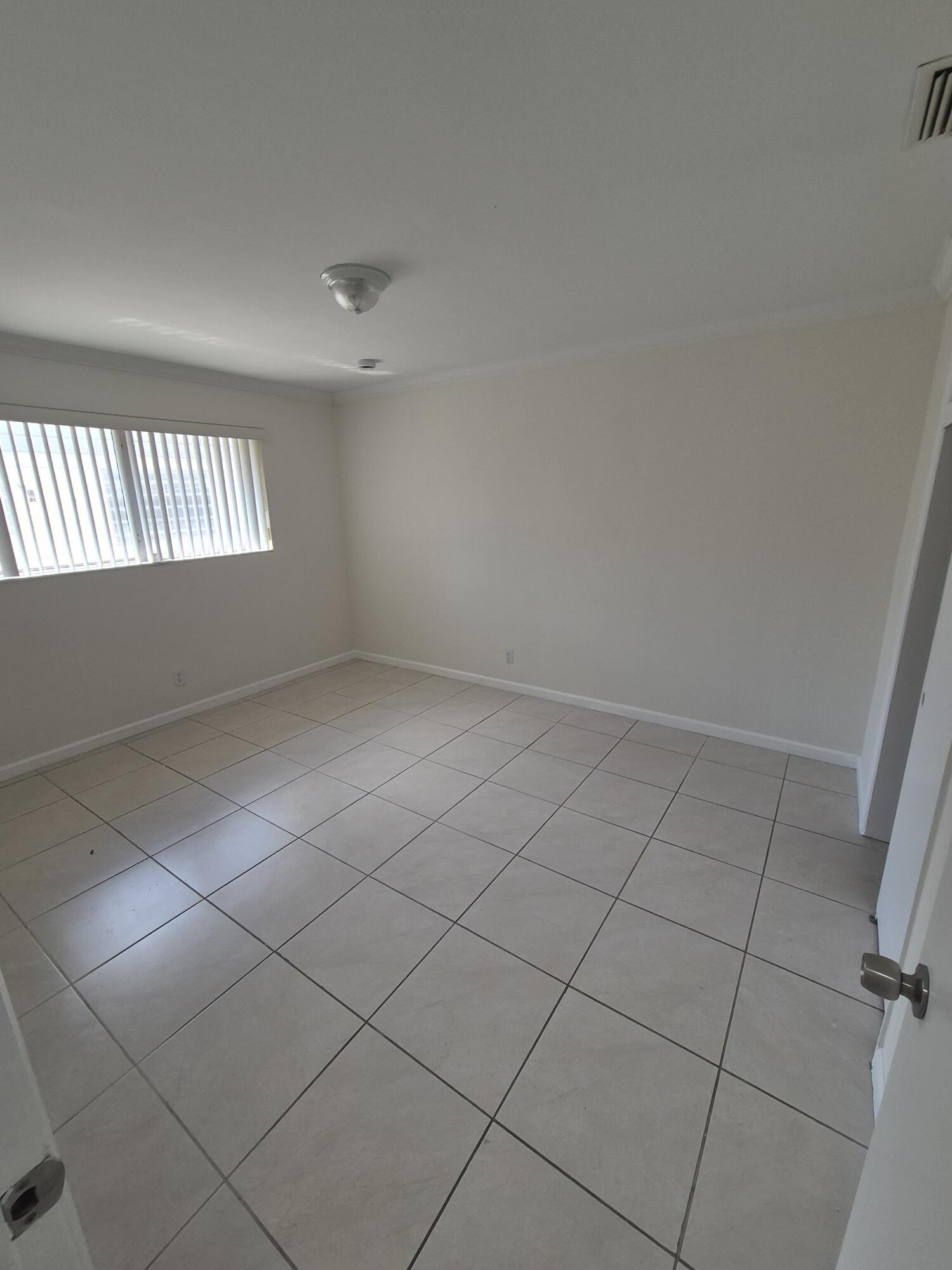 3518 Taylor Street, Unit 4 Hollywood, FL 33021 - Photo 12 of 13 an empty room with windows