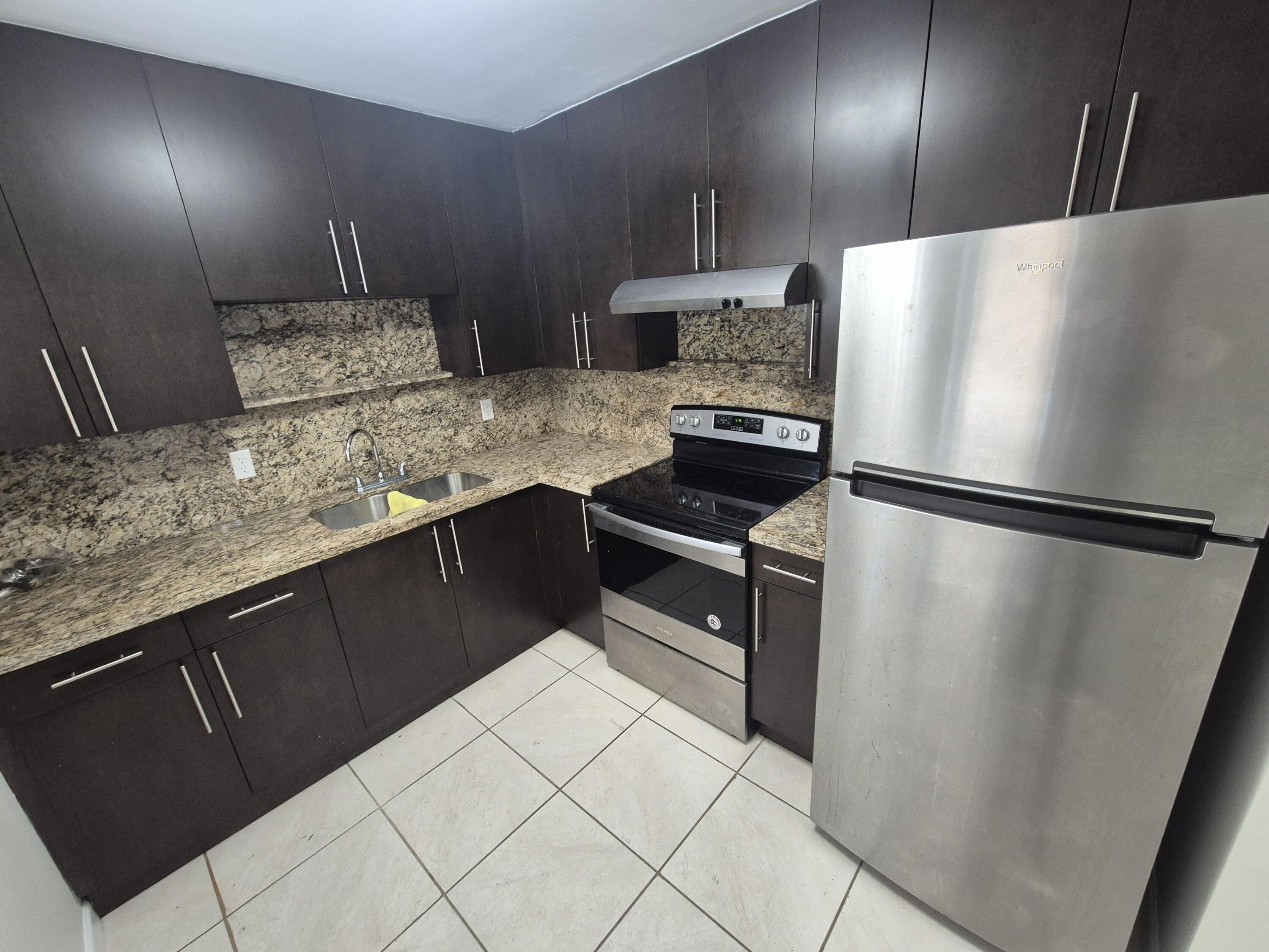 3518 Taylor Street, Unit 4 Hollywood, FL 33021 - Photo 2 of 13 a kitchen with granite countertop a refrigerator and a sink