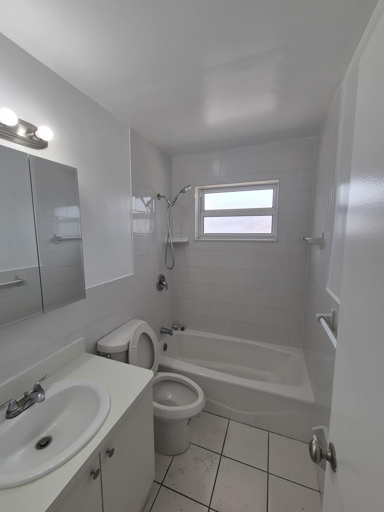 3518 Taylor Street, Unit 4 Hollywood, FL 33021 - Photo 4 of 13 a bathroom with a bathtub shower sink vanity and a toilet