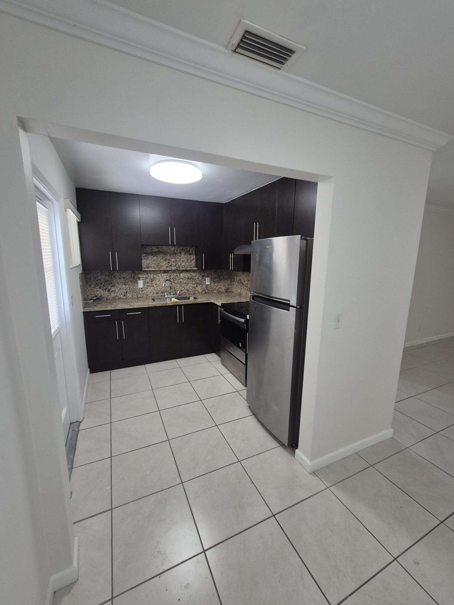 3518 Taylor Street, Unit 4 Hollywood, FL 33021 - Photo 5 of 13 a kitchen with stainless steel appliances granite countertop a refrigerator and a sink