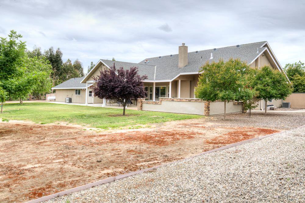 17465 Monreal Road Madera, CA 93636 - Photo 10 of 59 a view of a house with a yard and palm trees