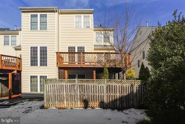a view of a house with a small yard and wooden fence