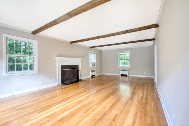 a view of empty room with wooden floor and fireplace