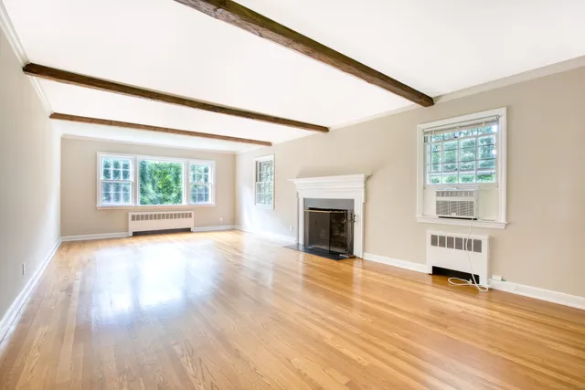 a view of empty room with wooden floor and fireplace