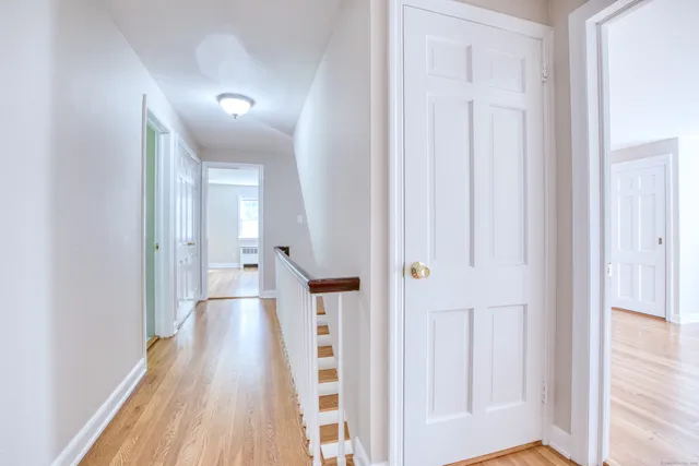 a view of a hallway with wooden floor and staircase