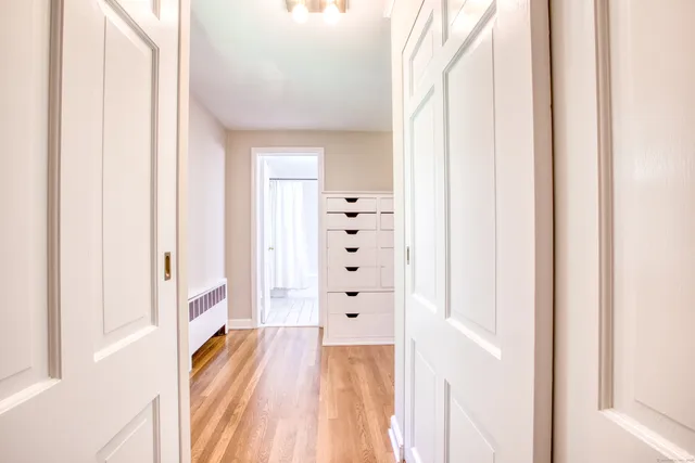 a view of a bedroom with wooden floor and windows