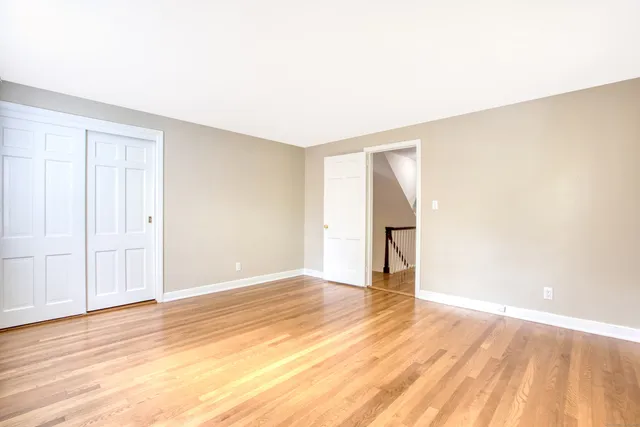 an empty room with wooden floor and a window