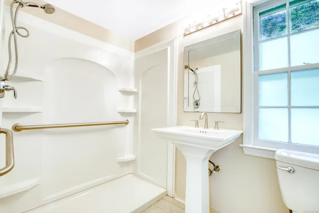 a bathroom with a sink mirror vanity and toilet