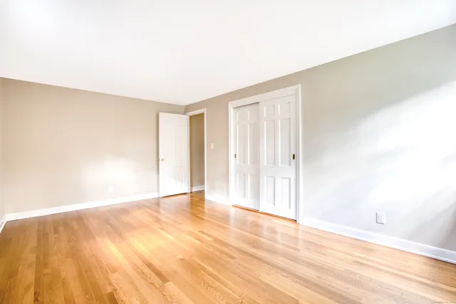 a view of an empty room with wooden floor