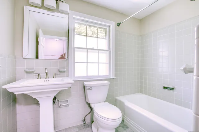 a bathroom with a sink toilet vanity mirror and bathtub
