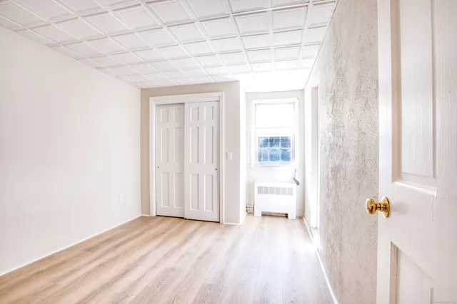a view of empty room with wooden floor