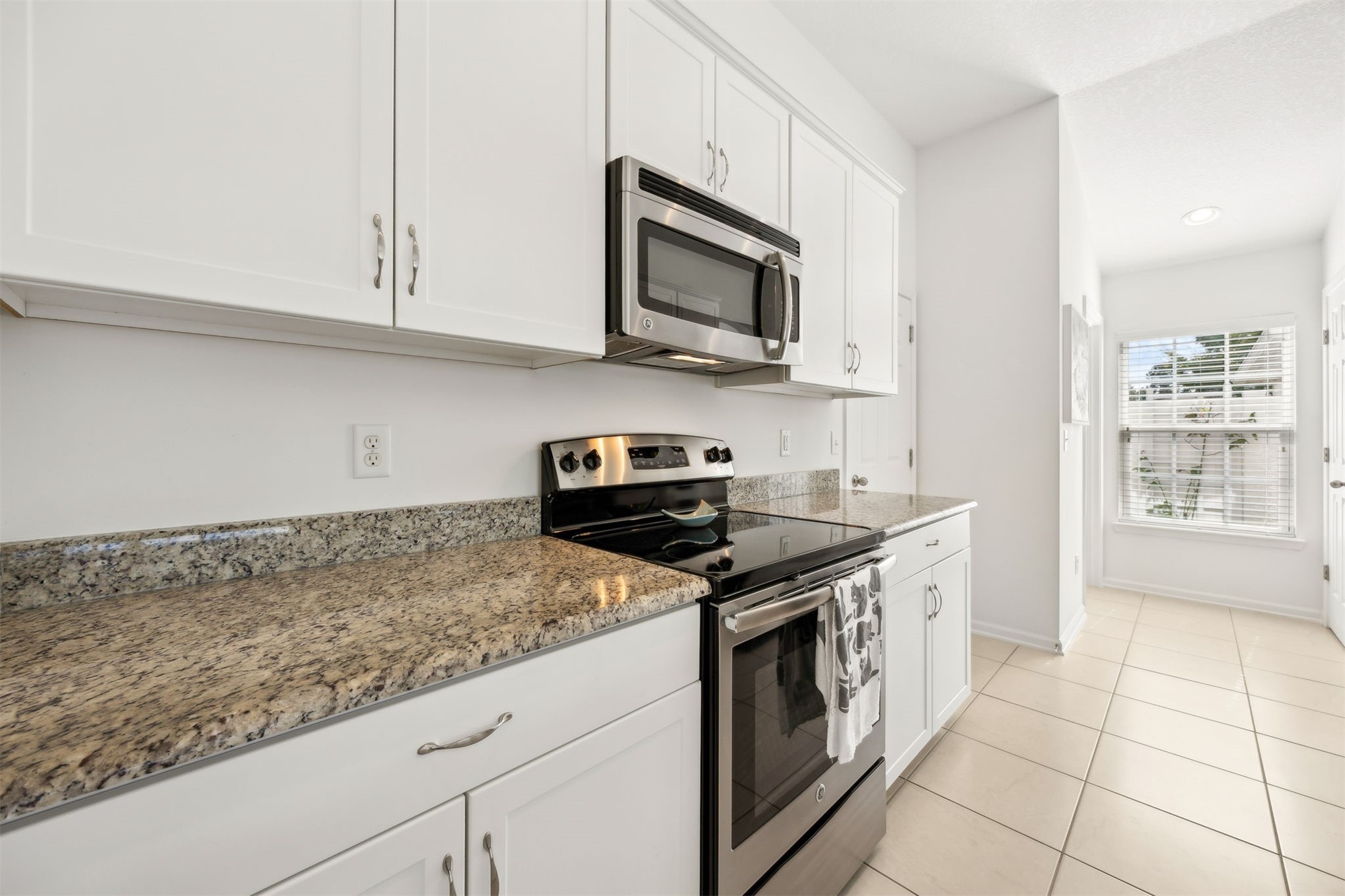94037 Last Lane Yulee, FL 32097 - Photo 9 of 38 a kitchen with stainless steel appliances granite countertop a sink stove and microwave