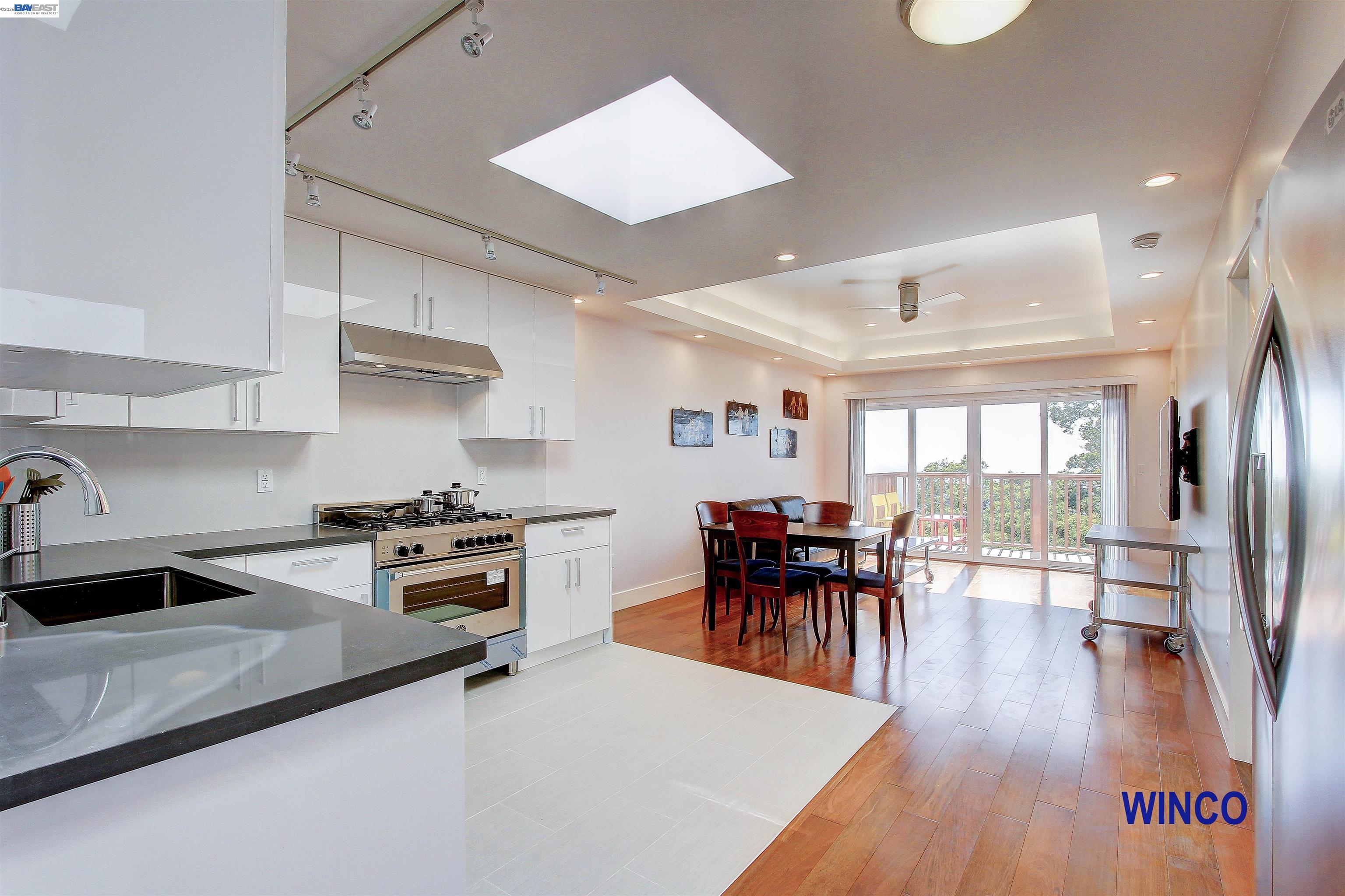 a kitchen with a table chairs stove and wooden floor