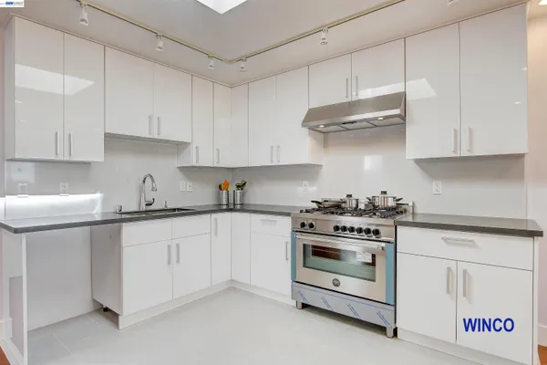 a kitchen with stainless steel appliances white cabinets and a stove a sink