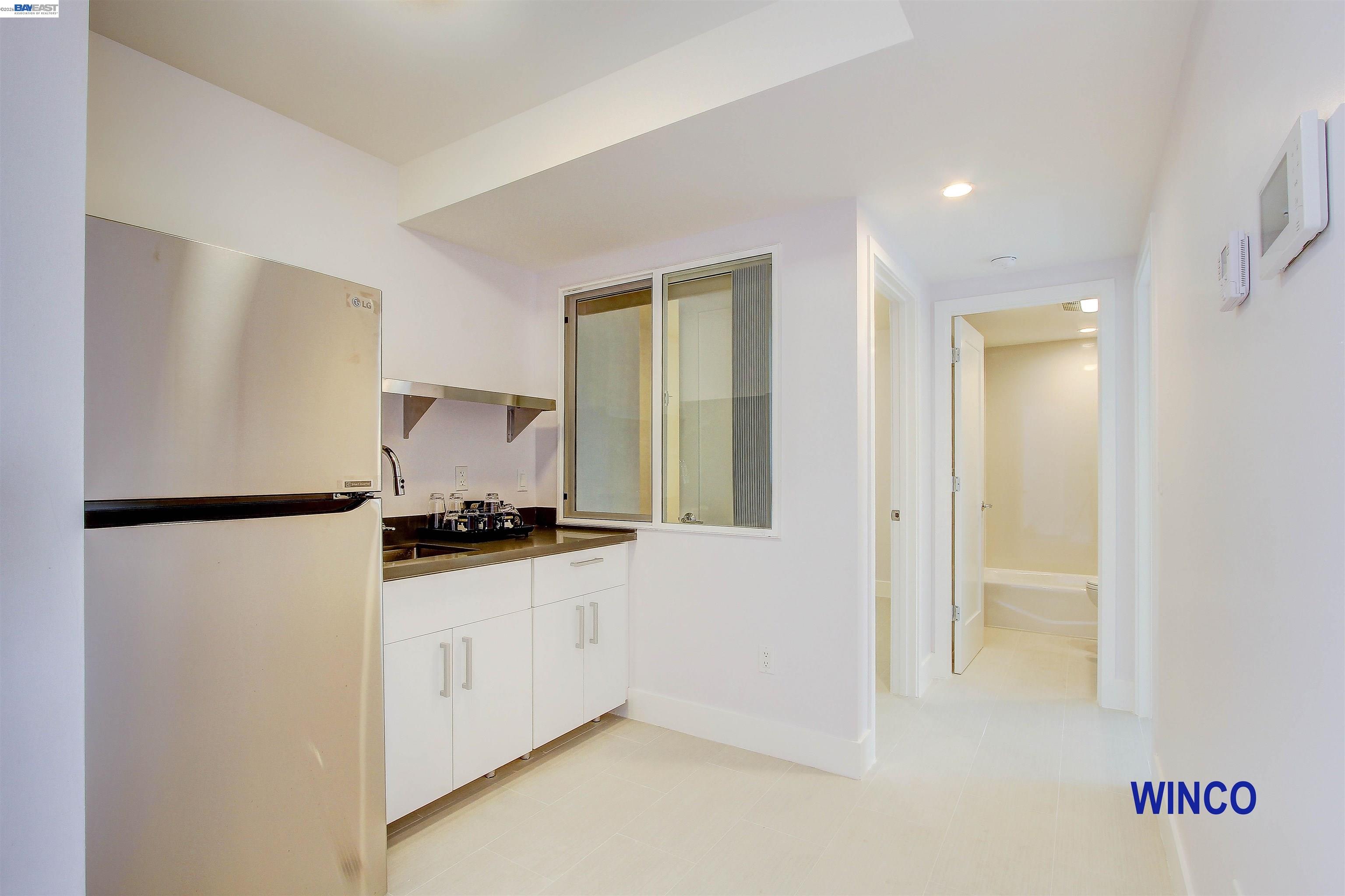 263 Ralston Street San Francisco, CA 94132 - Photo 5 of 28 a kitchen with stainless steel appliances a refrigerator a sink and white cabinets