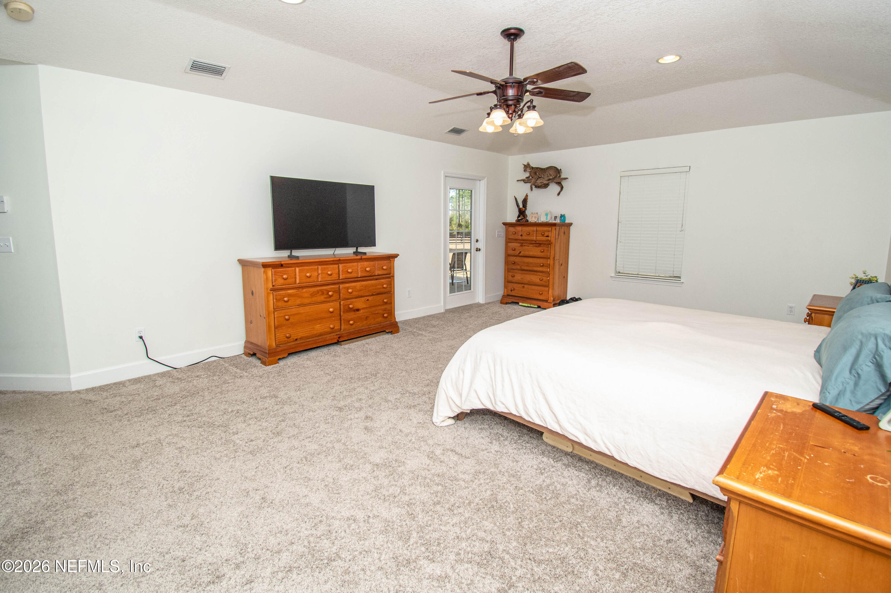 7733 Odis Yarborough Road Glen St. Mary, FL 32040 - Photo 24 of 45 a bedroom with a bed and a chandelier