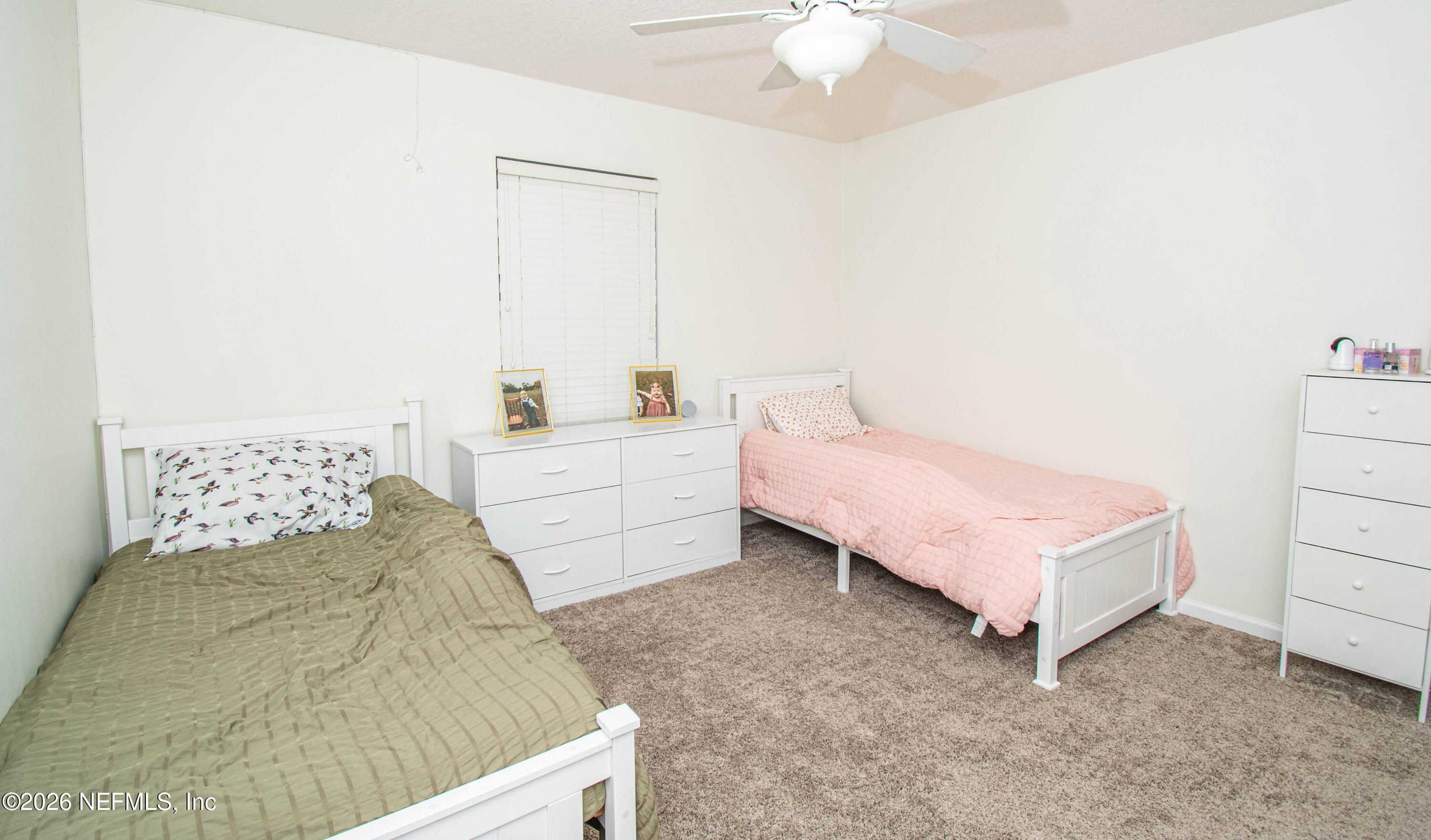 7733 Odis Yarborough Road Glen St. Mary, FL 32040 - Photo 30 of 45 a bedroom with a bed and a chandelier
