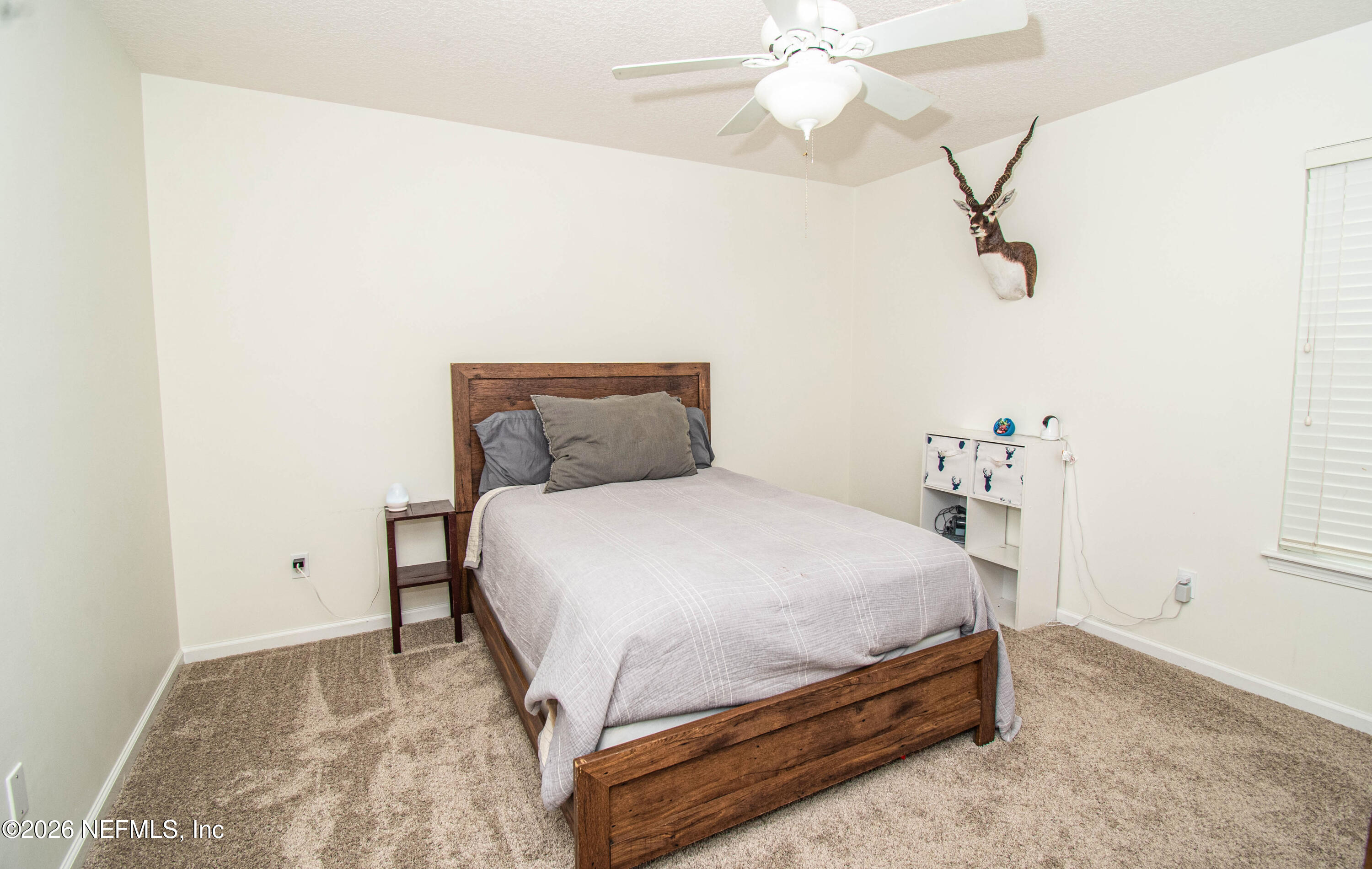 7733 Odis Yarborough Road Glen St. Mary, FL 32040 - Photo 34 of 45 a bedroom with a bed and a chandelier fan